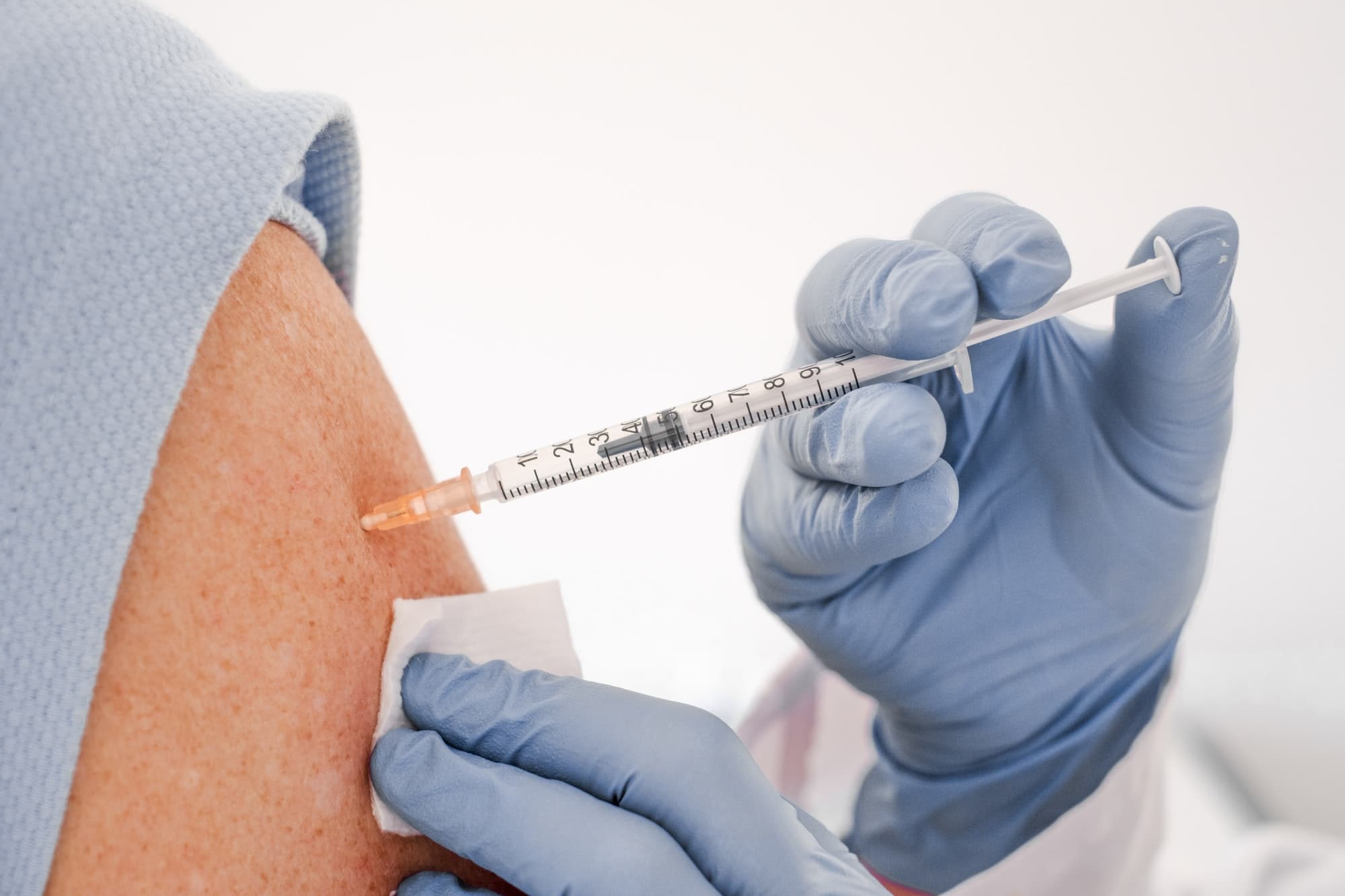 Booster covid-19 vaccine.Close up of a Doctor making a vaccine in the shoulder of patient