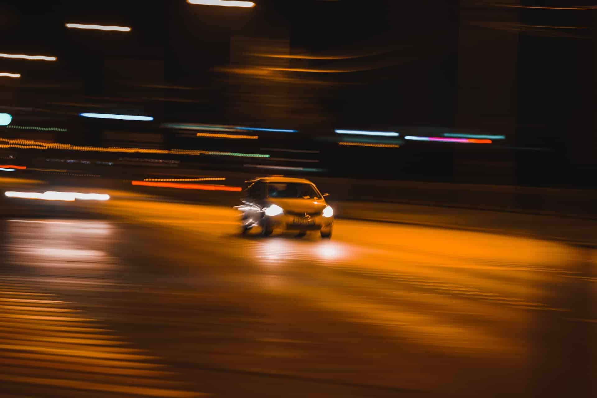 Car moving at speed on a night time road