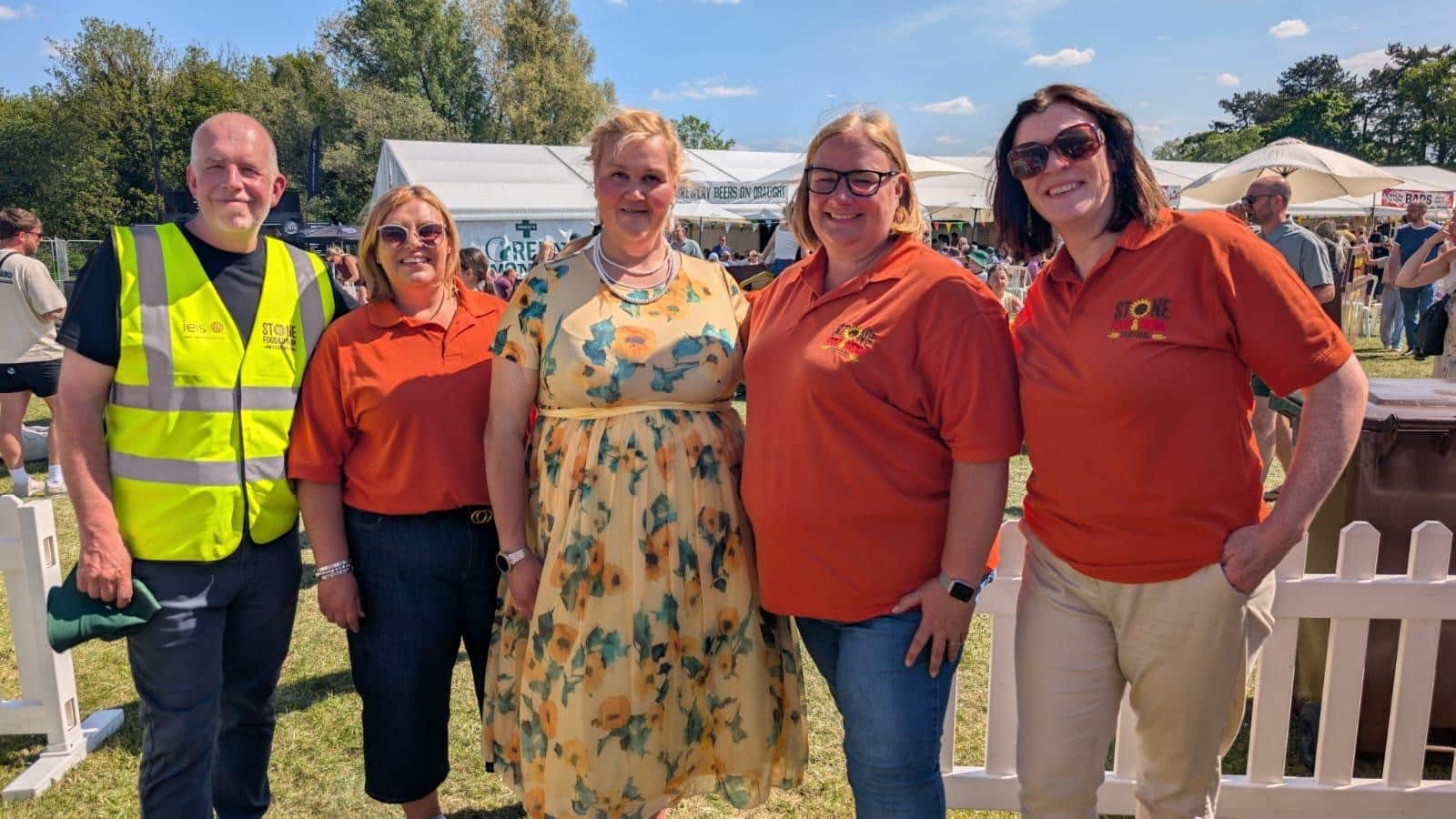 Stone Food & Drink Festival organisers pose with Bake Off star Nelly Ghaffar, standing in the centre, on a sunny day at Westbridge Park.
