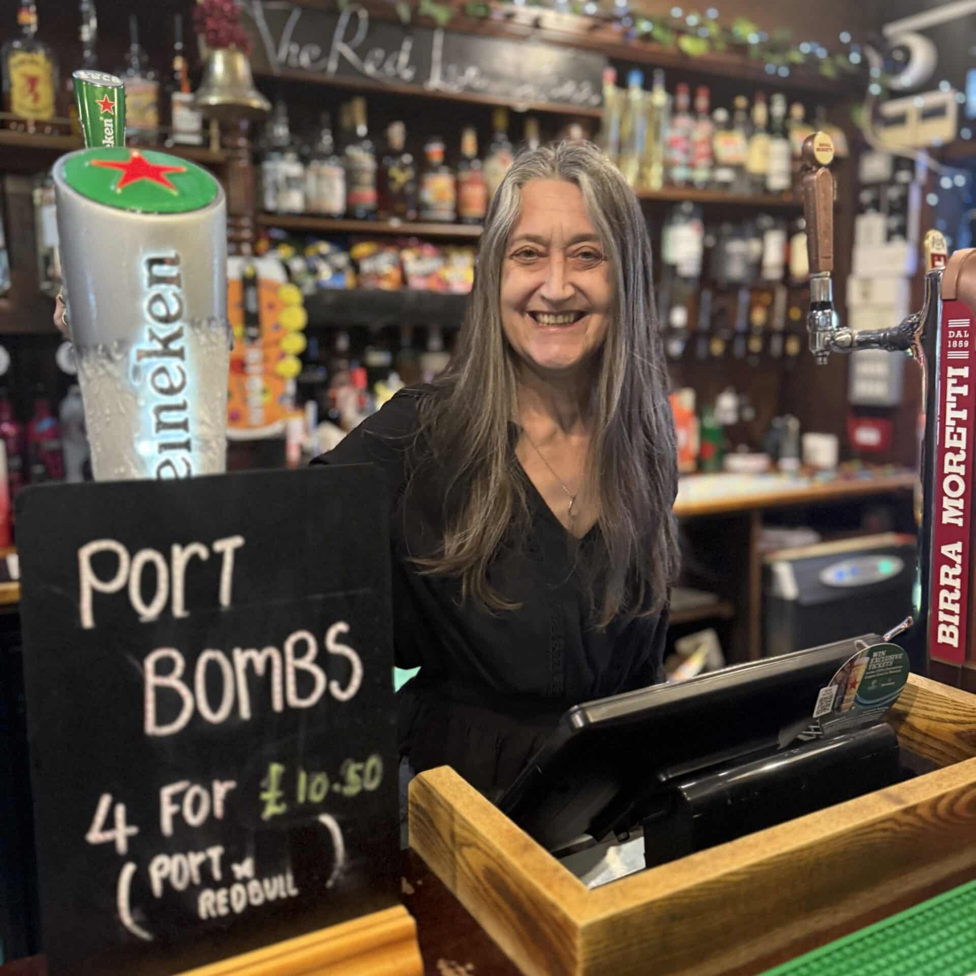 Tanya Moran, landlady of the Red Lion in Stone, smiling behind the bar during her final week before stepping down in May 2025.