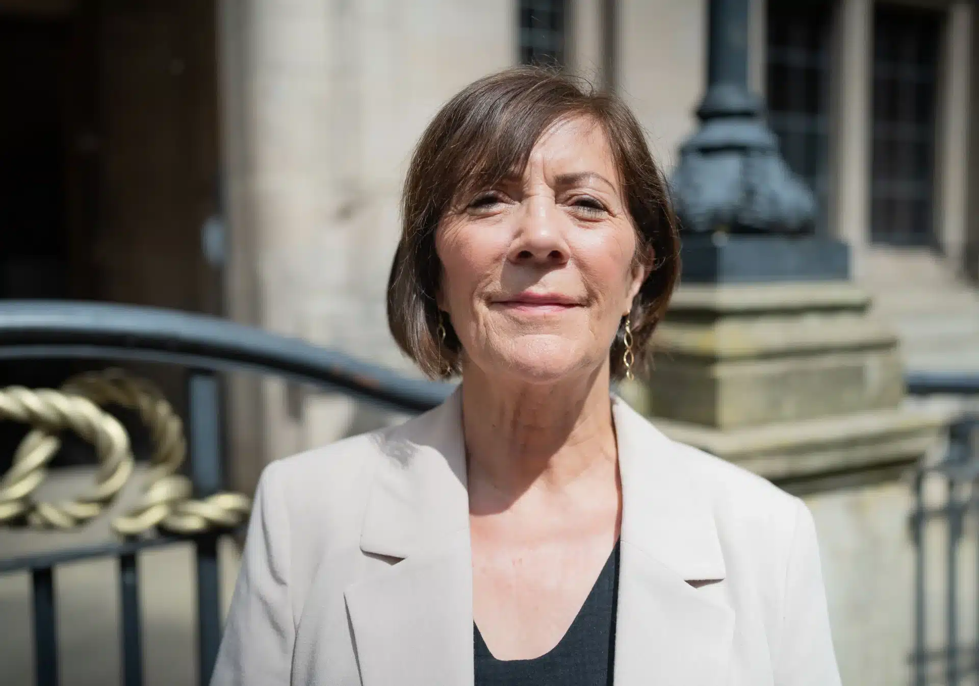 Janet Higgins, Cabinet Member for Education and SEND at Staffordshire County Council, standing outside a civic building, wearing a light-coloured jacket and dark top.