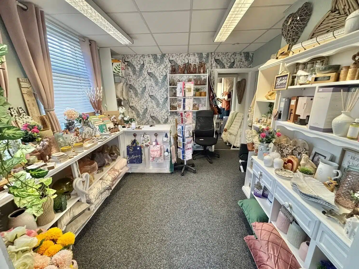 Giftware and home decor section at LCT Homewares with greeting cards, vases, shelving and a floral display.