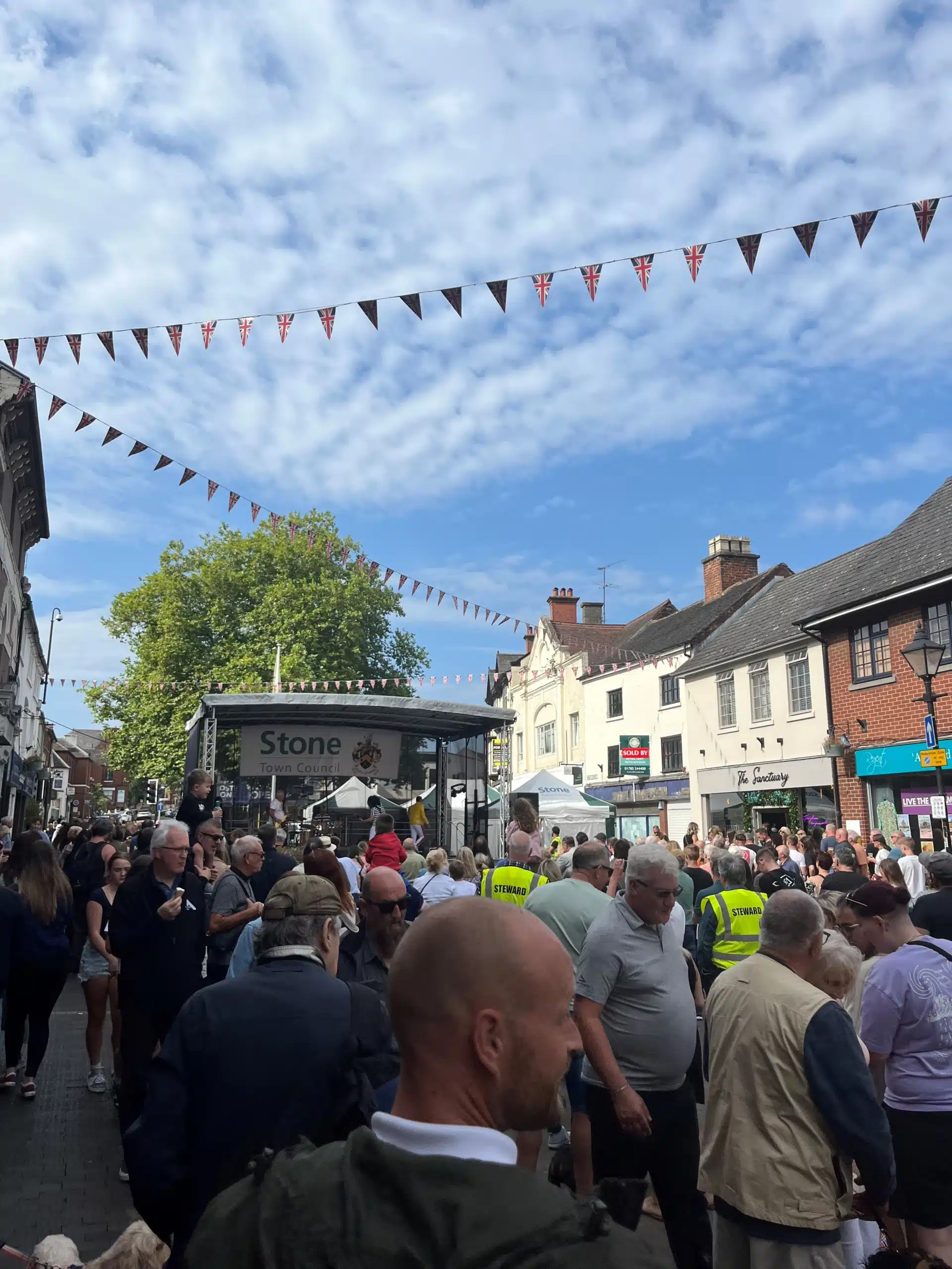 The crowd watches a band perform on stage during Stone’s Summer Street Party