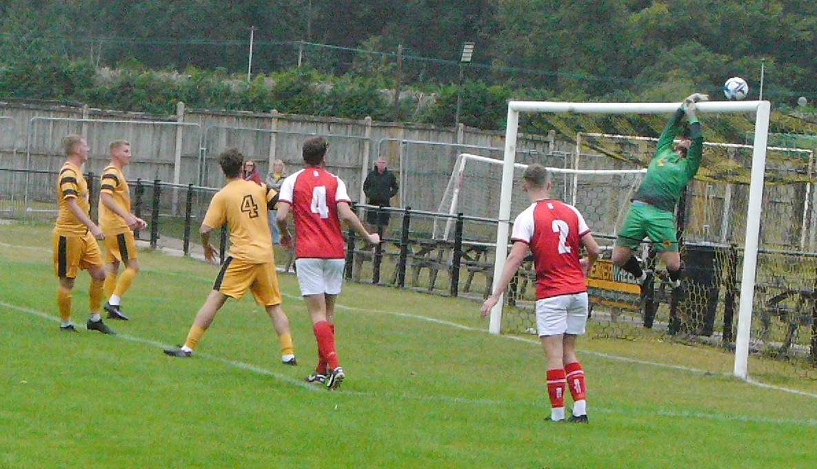 Stourport goalkeeper tips a looping header from Luke Askey over the crossbar to deny Stone Old Alleynians.