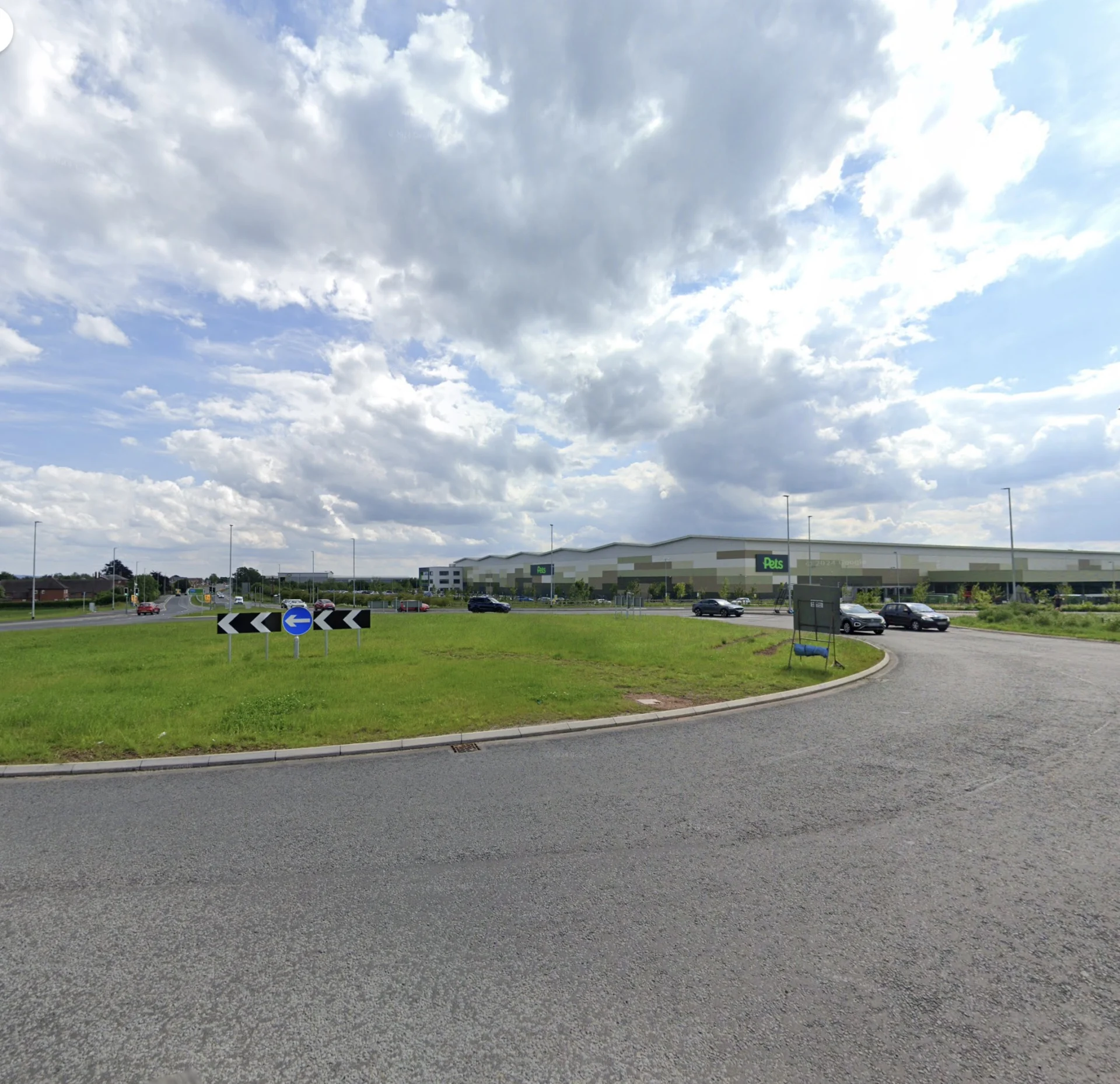View of the Pets at Home roundabout on the A34 near Stafford, showing traffic and store in the background under a partly cloudy sky