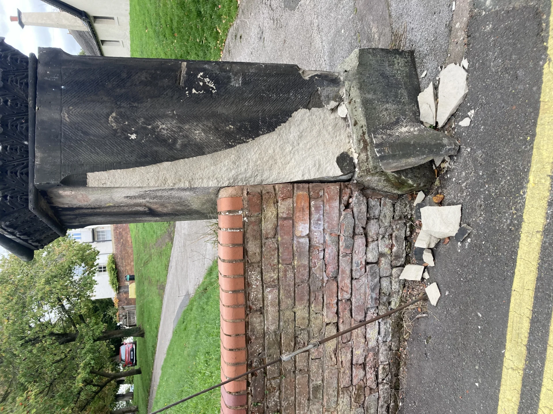 Close-up of damage to the stone gateway and brick wall at the entrance to St Michael’s Church in Stone, showing fallen masonry on the pavement.