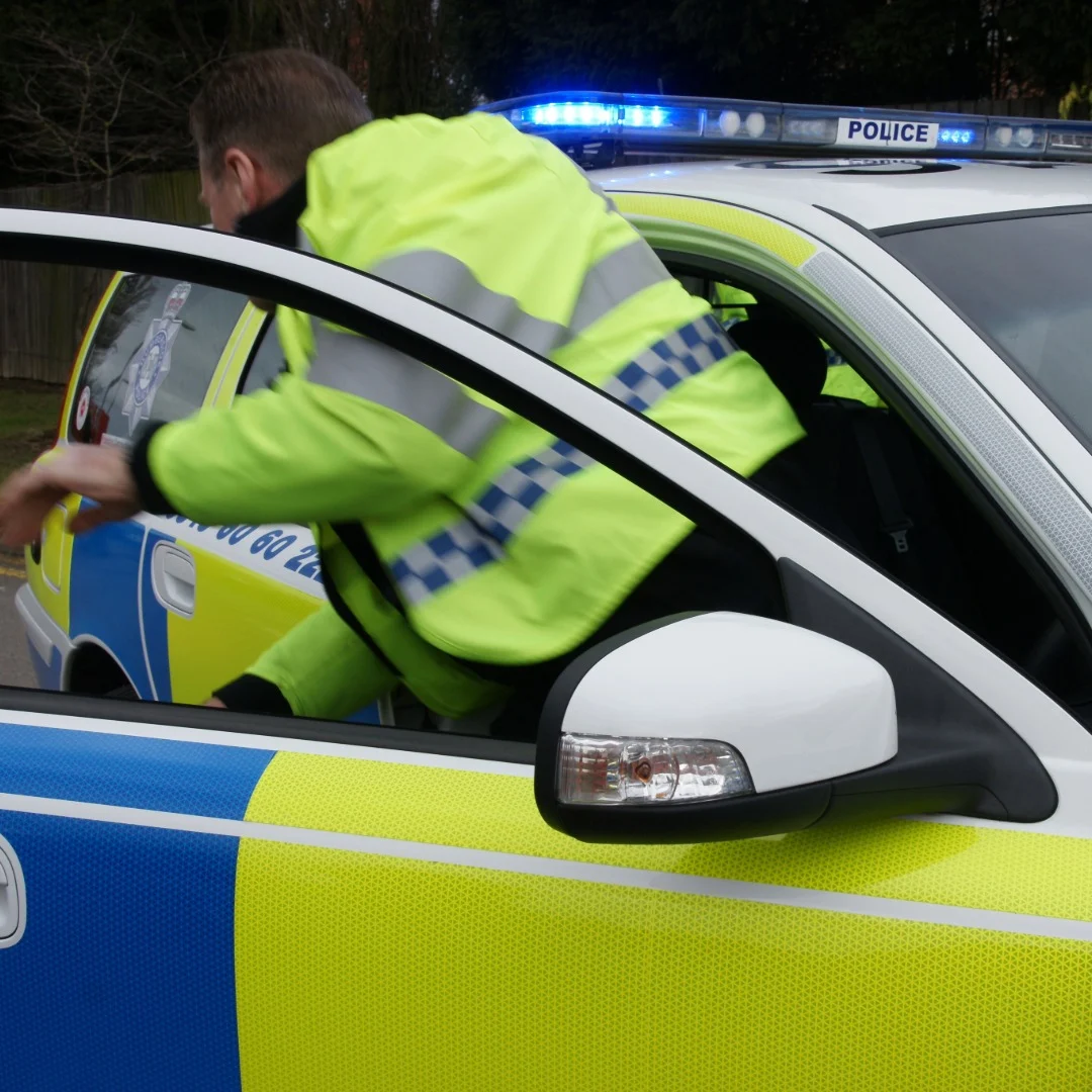 Policeman leaving a police car
