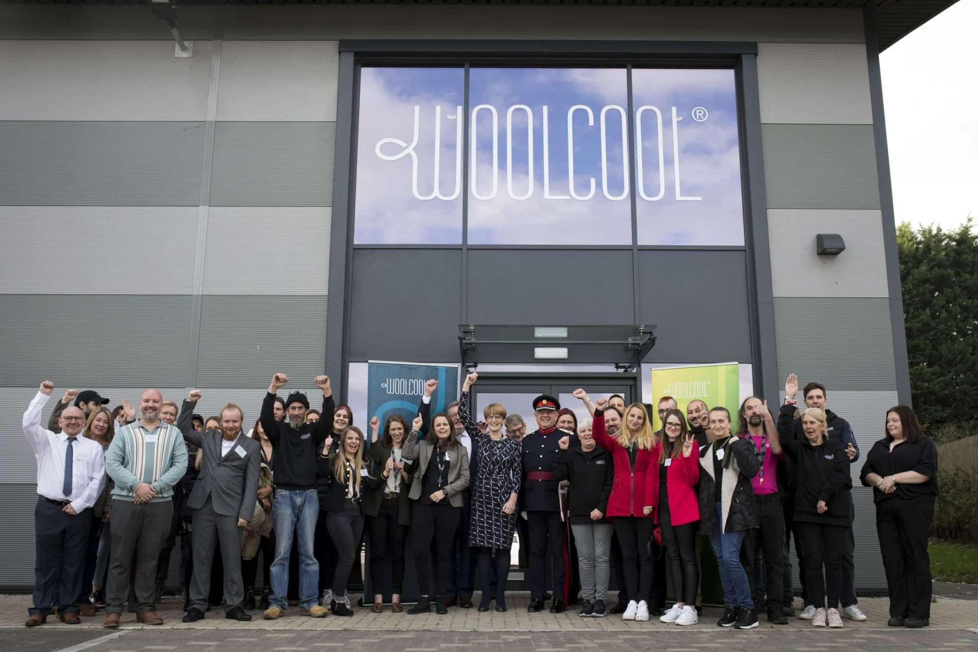 Woolcool team members standing outside the company’s Stone premises celebrating the King’s Award for Enterprise.