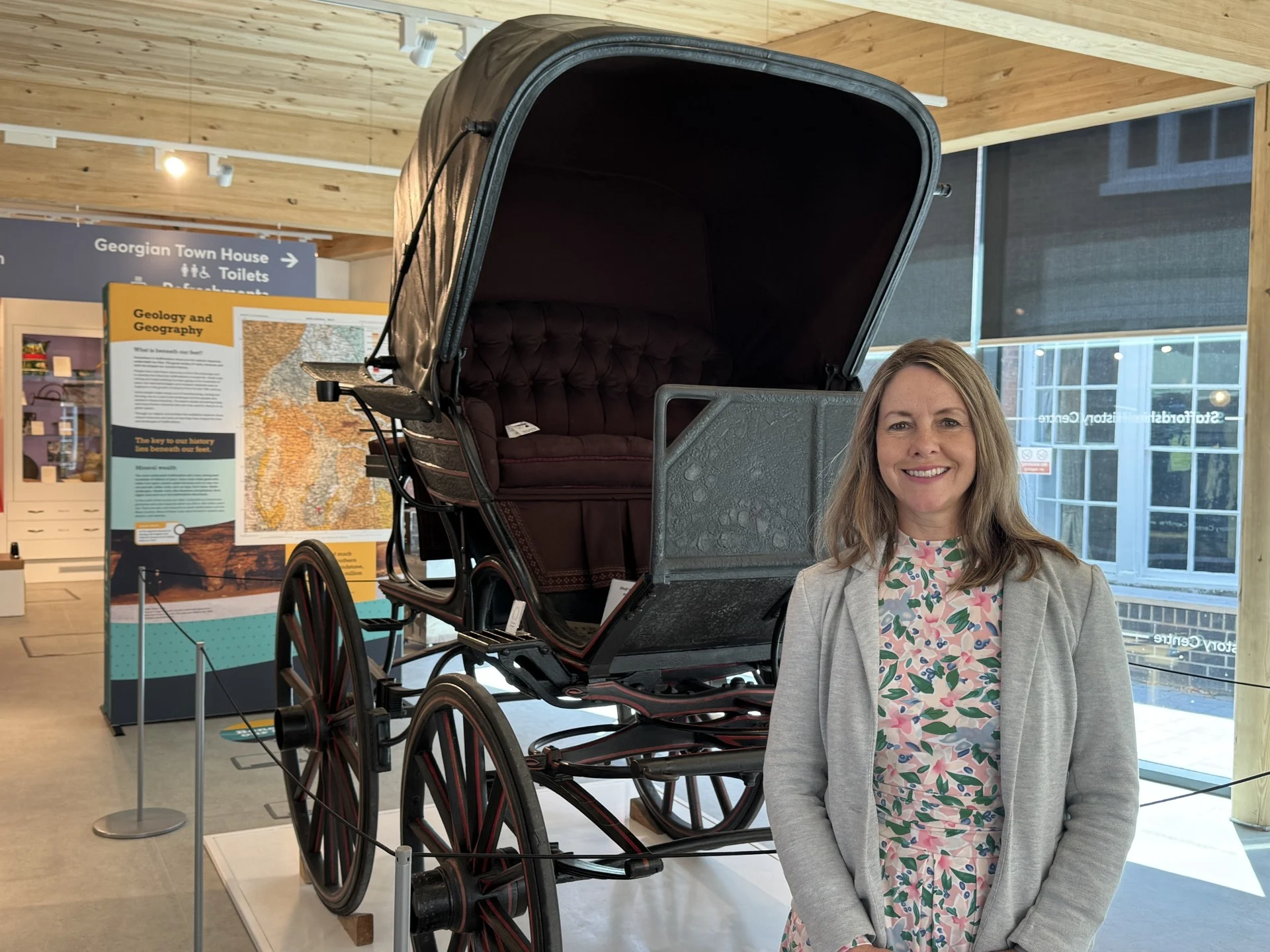 Hayley Coles standing beside a carriage display inside Staffordshire History Centre in Stafford.
