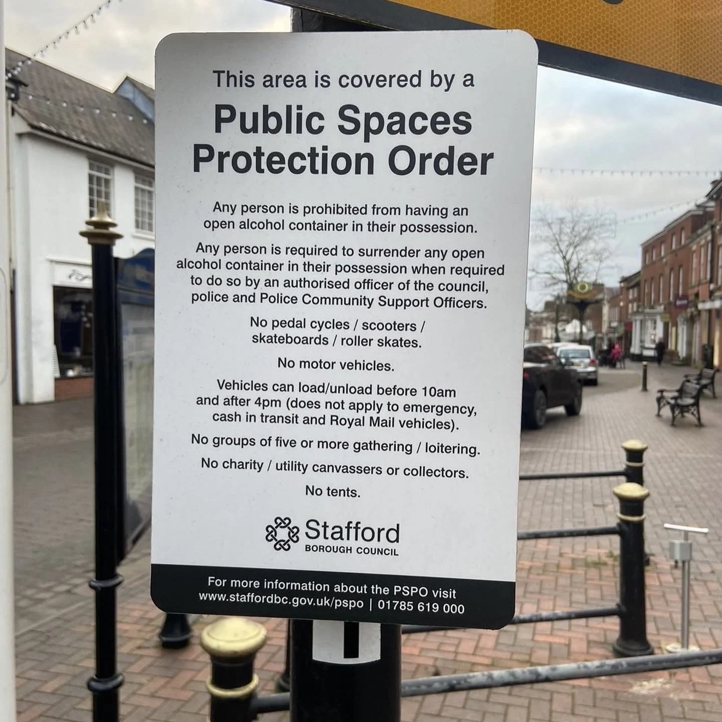 A Public Spaces Protection Order sign in Stone town centre listing restrictions on alcohol, cycles, scooters, vehicles, tents, loitering and canvassing.
