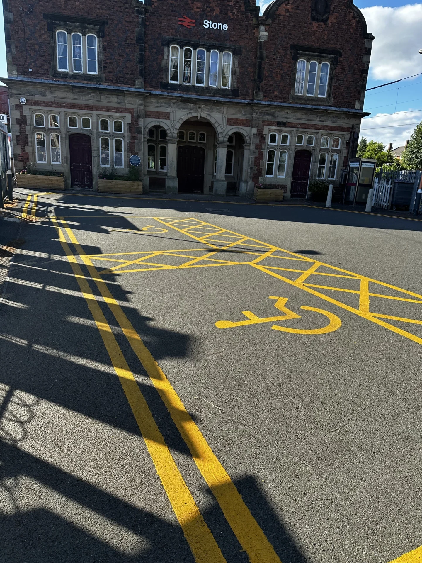 Newly painted disabled parking bays and yellow road markings outside Stone railway station.