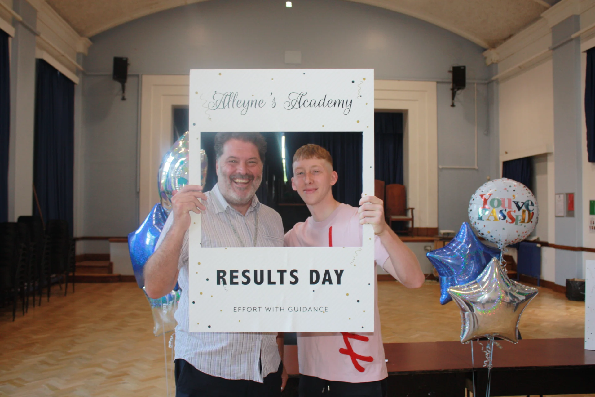 An Alleyne’s Academy student holding a Results Day photo frame in the school hall in Stone.