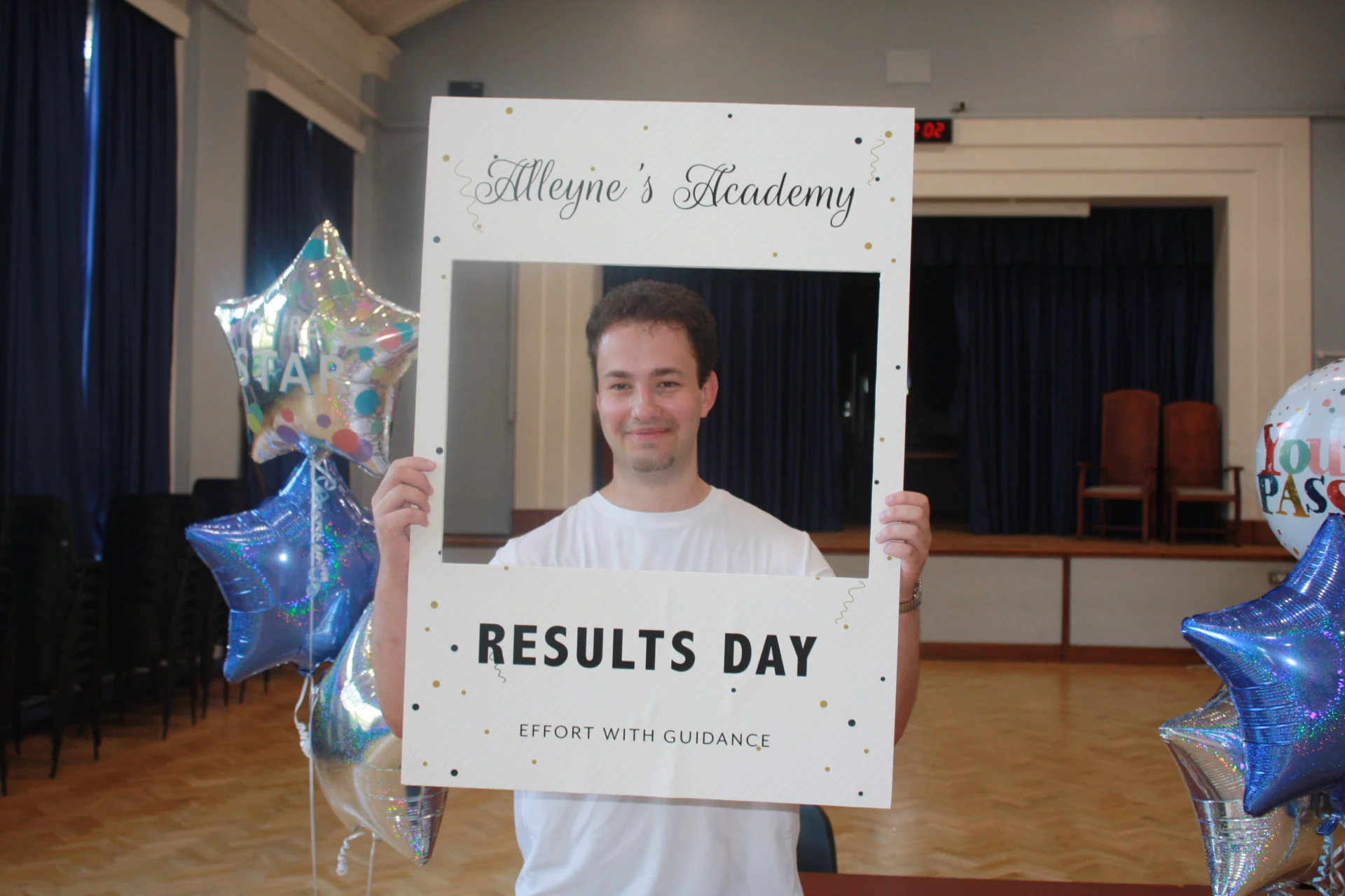 An Alleyne’s Academy student holding a Results Day photo frame in the school hall in Stone.