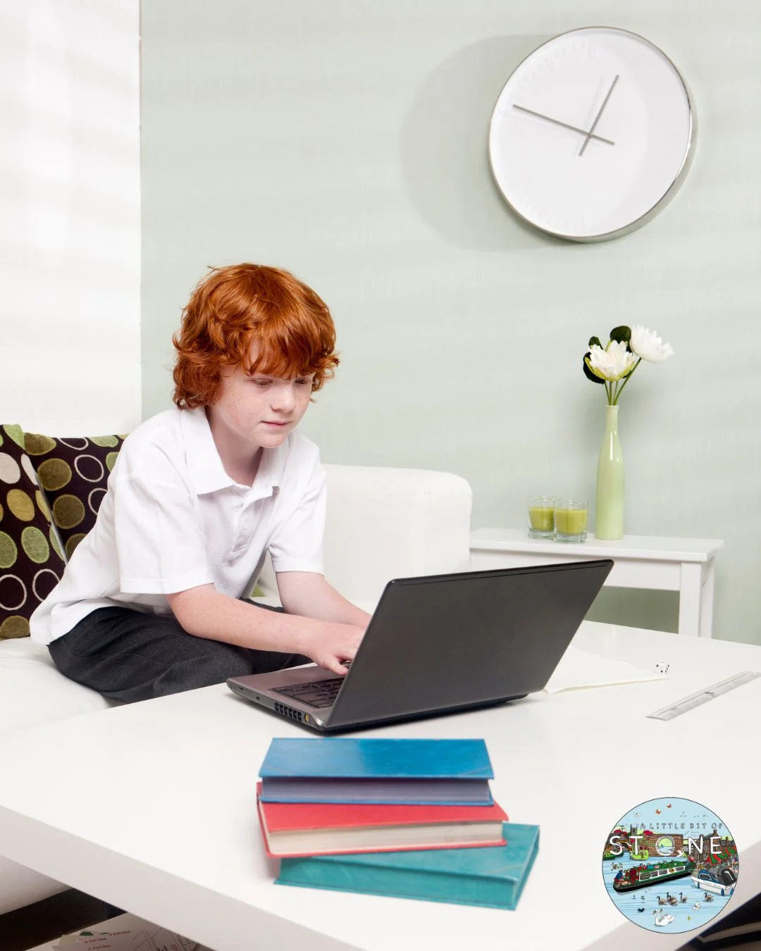 School aged child studying on a laptop with reference books around them