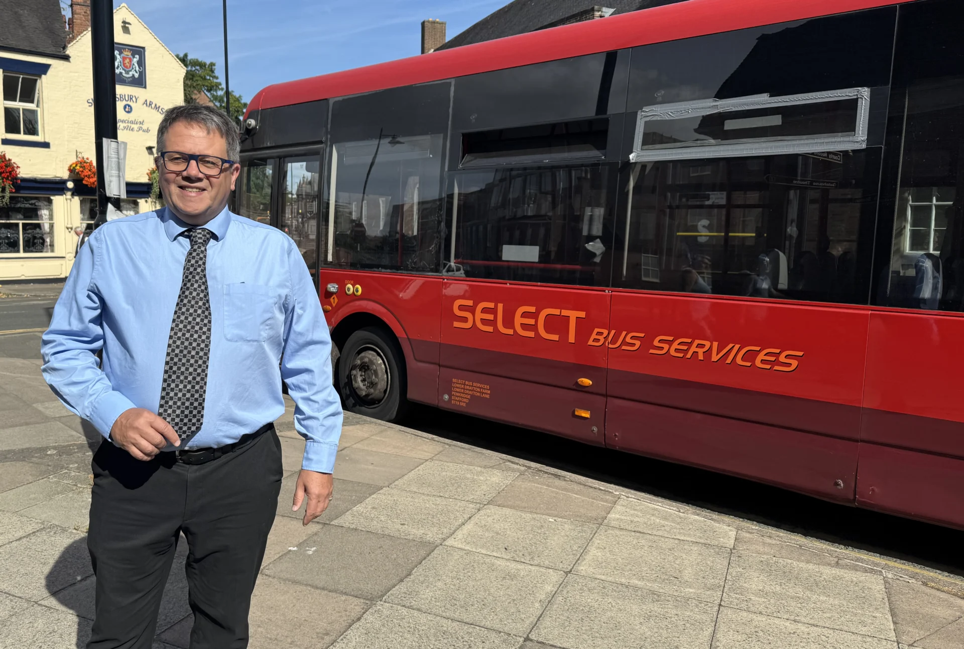 Staffordshire County Council Cabinet Member for Connectivity Andrew Mynors standing beside a Select Bus Services bus.