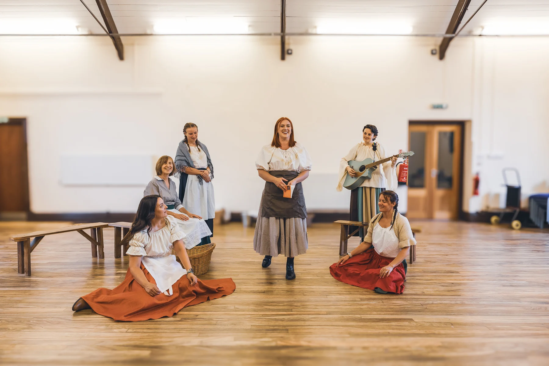 Six members of Stone Revellers rehearsing The Ballad of Maria Marten, with performers in period costume and one holding a guitar.