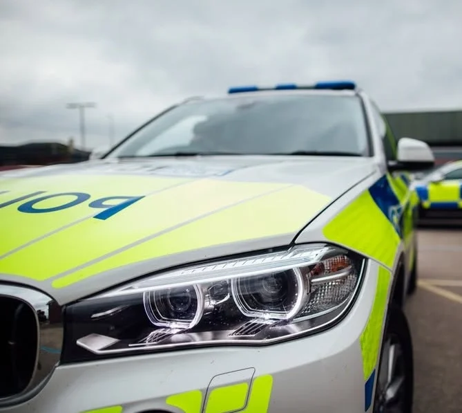 Marked Staffordshire Police vehicles parked outside a police building.