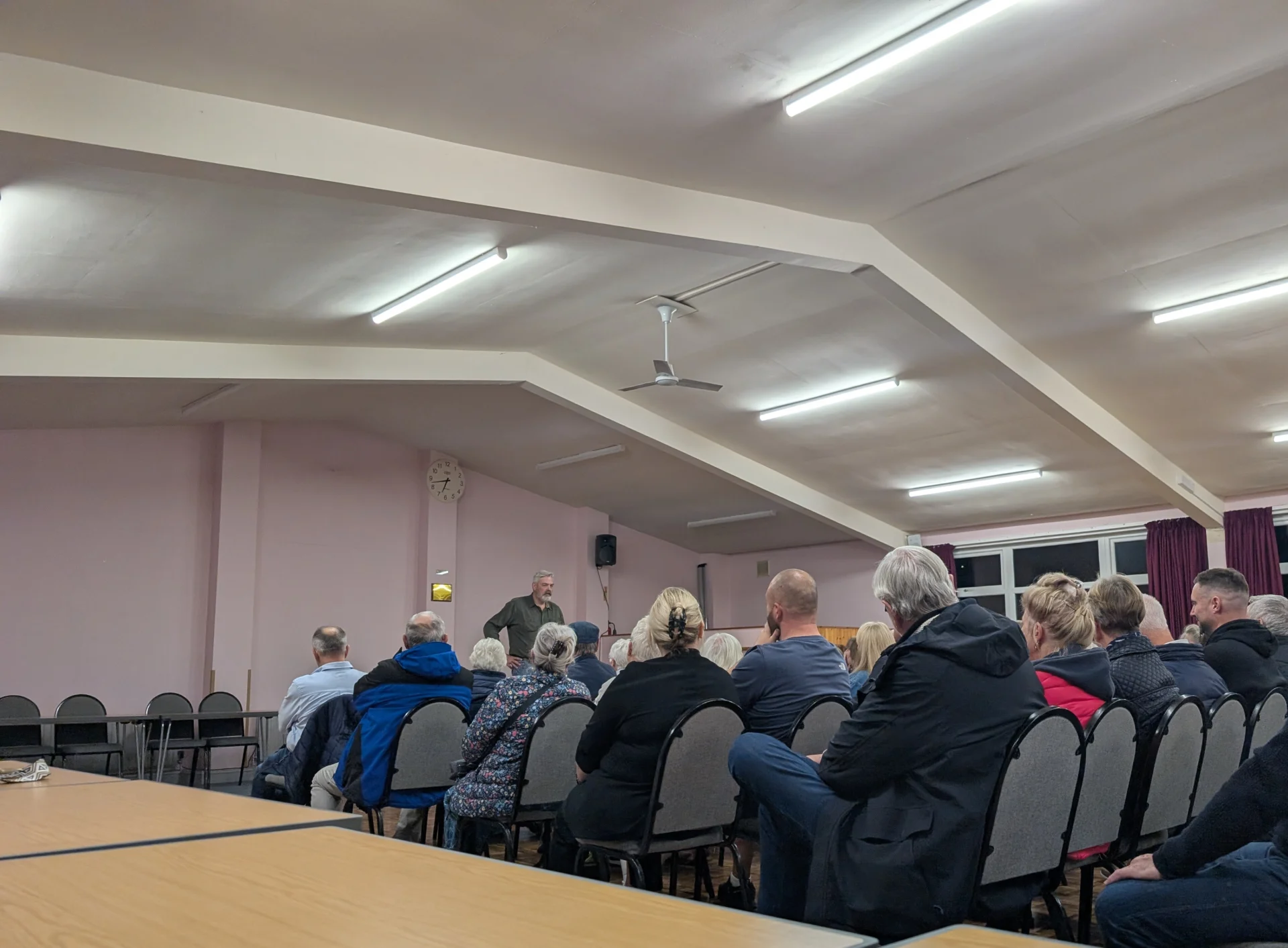 Residents seated at Walton Community Centre listening to a speaker during a meeting about housing plans for Stone.